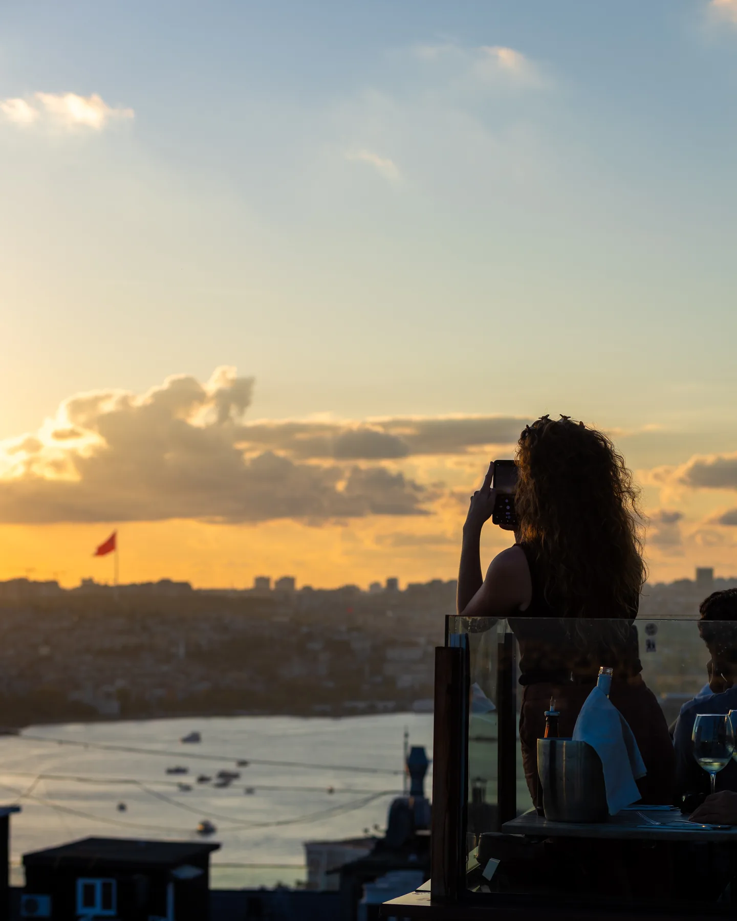 Bir misafir Balkon’dan gün batımını telefonuyla çekerken